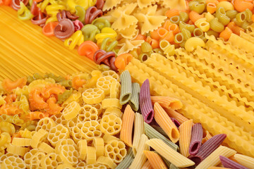 Assortment of colored uncooked Italian pasta close up