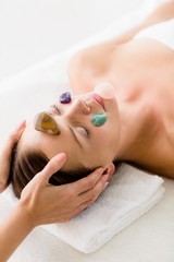 Obraz na płótnie Canvas Woman receiving facial stone massage from masseur