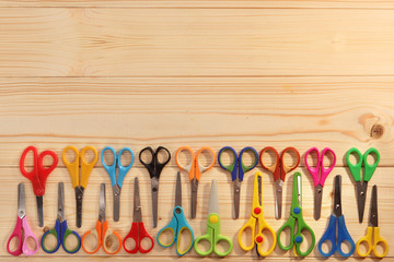 Bright scissors for kids on wooden background