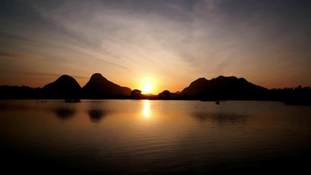 Time lapse of beautiful sunrise by the lakeside with hills