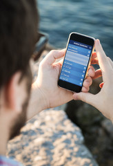 Man with sunglasses using the smartphone with mobile banking nea