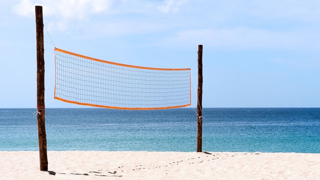 Volleyball net at beach. A volleyball net on beach with blue sea, clear and sunny sky.
