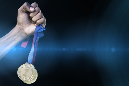 Hand holding two gold medals 