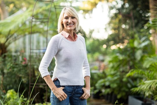 Confident mature woman standing at greenhouse