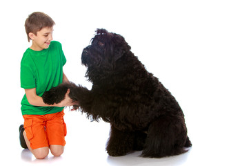 The young man holds the paw of a black dog-Isolated on white background