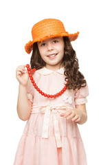 Beautiful little girl with long dark hair , orange hat, trying on a big red beads. Close-up - Isolated on white background