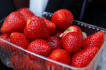 Juicy strawberries closeup in container. Useful vitamin food. Delicious gifts of nature. Meal of...