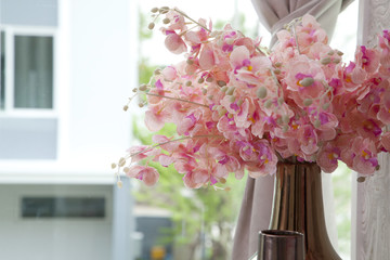 Bouquet of pink flower in vase near the window