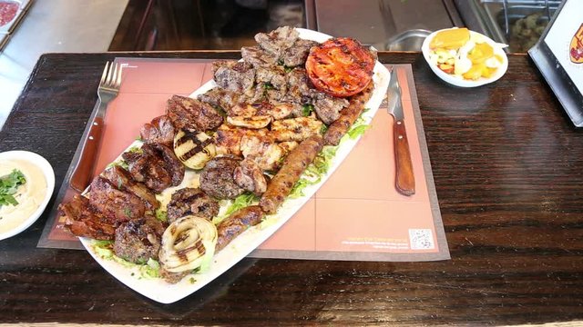 Serving a big mix grill meats plate