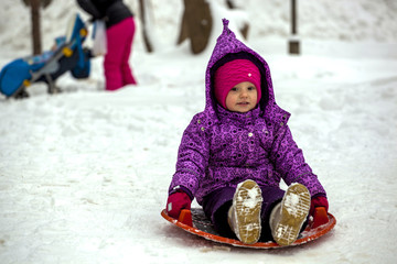 The child rolls off the ice slide