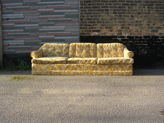Vintage old discarded couch outdoors in alley