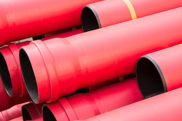 Stack of red pvc protective pipes