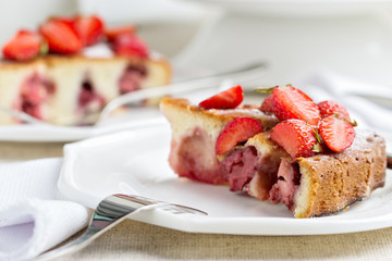 Homemade strawberry cake on a white cake stand.