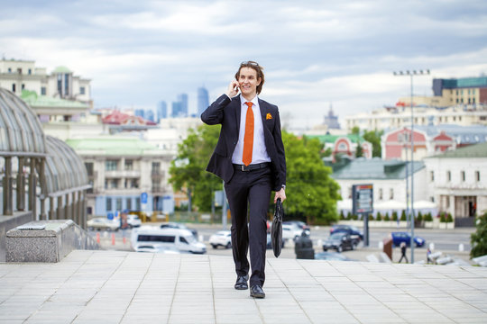 Young successful businessman calling by phone