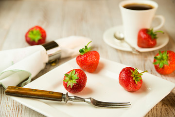 Ripe strawberry fruits on a white plate