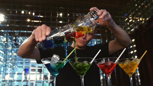 young man working as a bartender in a nightclub bar