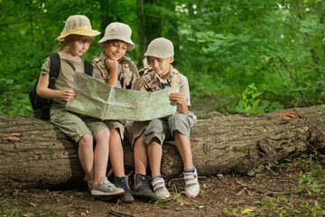 summer camps,scout children camping and read map in forest - obrazy, fototapety, plakaty