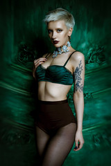 Fototapeta premium Studio portrait of beautiful fashionable woman with perfect sexy lingerie. Stylish girl, bright makeup, shorts, black tank top. 