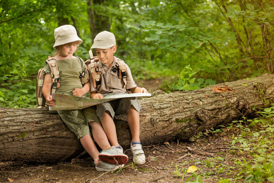 summer camps,scout children camping and read map in forest