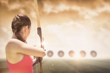 Rear view of sportswoman doing archery  - obrazy, fototapety, plakaty