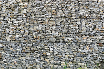 Wall of stones in a metal grid