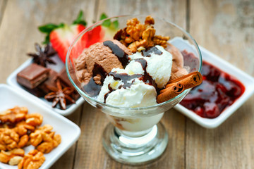 Ice cream sundae, chocolate, walnuts, sliced strawberry and jam
