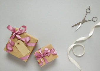 Gift wrap - Presents wrapped in brown parcel paper with pink silk bows, white ribbon and scissors...