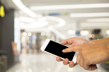 Hand hold smartphone on blur shopping mall