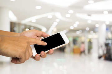 Hand hold smartphone on blur shopping mall