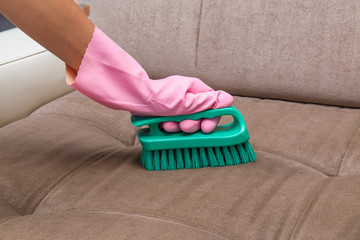 Sofa chemical cleaning with professionally brush. Upholstered furniture cleaning. Early spring cleaning or regular clean up.