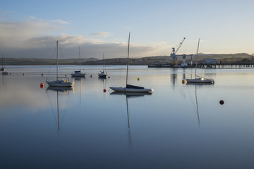 Fototapeta na wymiar River Tamar at sunrise with boats and reflections , Devon and Cornwall Uk