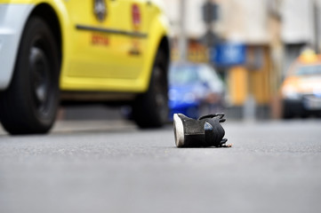 Shoe on the street with cars in background after accident