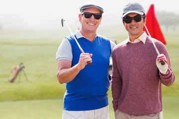 Naklejka premium Composite image of men holding golf club