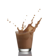 chocolate milk or protein milkshake flowing into a glass, making  big splash, isolated on white background