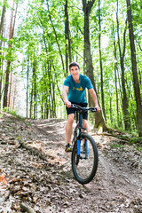 Fototapeta premium Mann auf Mountainbike Fahrrad am Berg im Wald