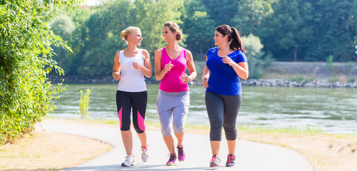 Gruppe von Frauen beim Laufen am Flussufer