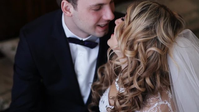 Bride and groom kissing in a stylish interior
