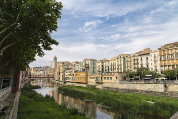 Fototapeta na wymiar Skyline of the beautiful city and the river in Girona, Catalonia. Old cathedral with old river houses and river reflection