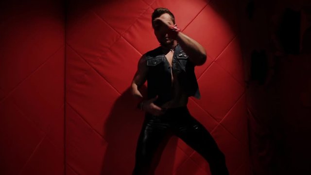 Brutal muscular man in the red room dancing