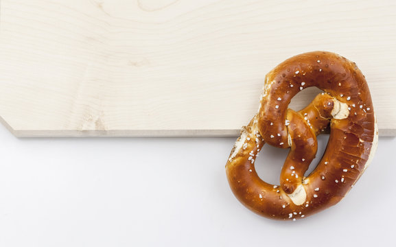 Eine Brezen liegt auf einem Holzbrett, wo ist die Wei&szlig;wurst?  