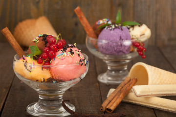 Ice cream dessert in two glass bowls with fresh currant, mint and chocolate crumbs