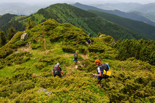 Group of tourists with large backpacks are on mountain