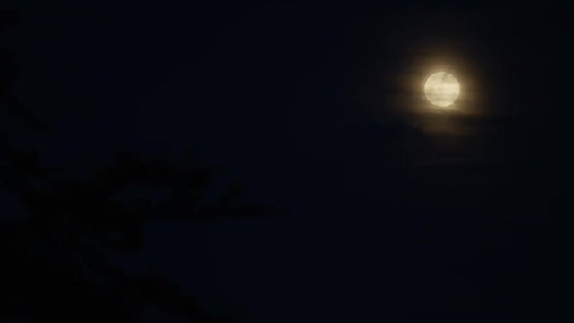 4K Dark clouds drift past a bright full moon