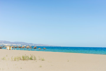 Fototapeta na wymiar Beautiful mediterranean beach with hammocks and sun umbrellas
