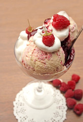 Raspberry ice  cream with fresh raspberries and whipped cream, selective focus
