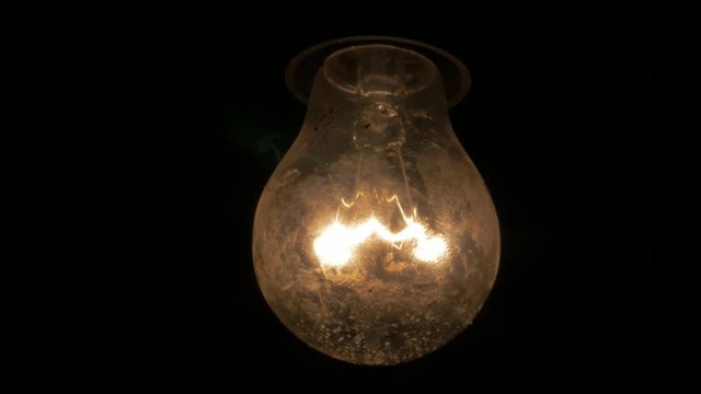 Old dirty light bulb swing and calm down in the dark 4K 3840X2160 UHD video - Dark scary scene with light bulb swinging and calming down 4K 2160p UHD footage 