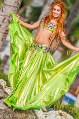 young beautful woman in awesome green dress for belly dance on t
