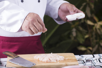 Chef putting Salt to the chicken befor cooking