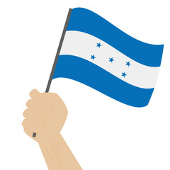 Hand holding and raising the national flag of Honduras