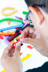 Close up. Child molding model clay, on white background. 